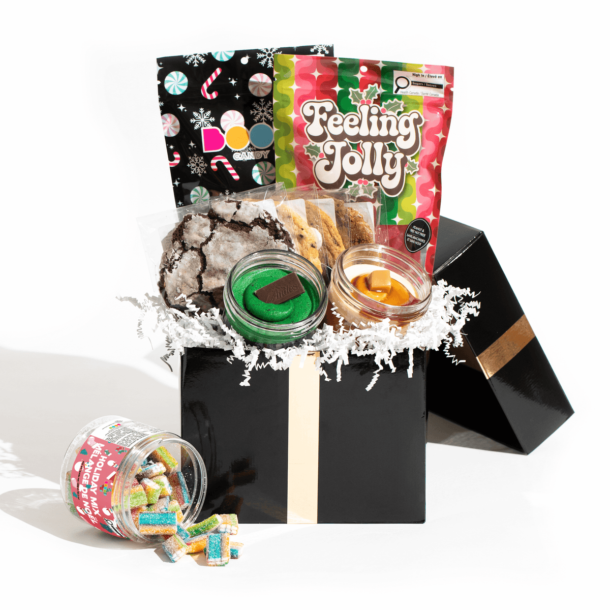 The Holiday Essentials Box, a festive gift set containing Jarcakes, cookies, and Christmas-themed Boom Candy assortment, for delivery in Toronto.