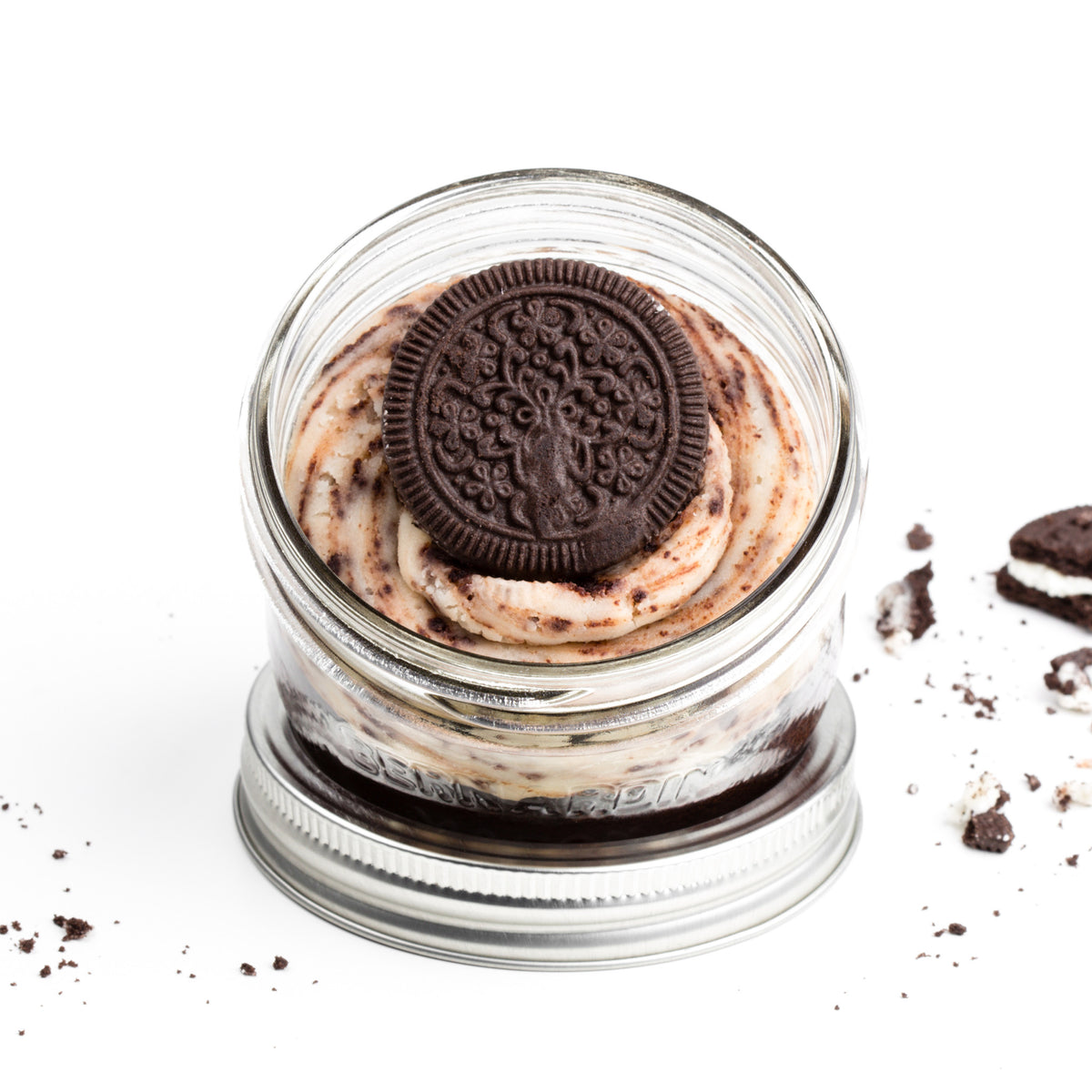 Cookies & Cream Jarcake (available in Mini/Regular sizes) in a jar with personalized sticker option, vanilla cream frosting, and crushed soft chocolate cookies for nut-free delivery in Toronto.