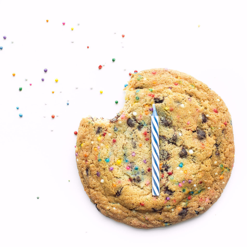 Single Birthday nut-free cookie, individually wrapped, with rainbow sprinkles and a candle on top for a gift box delivery in Toronto.