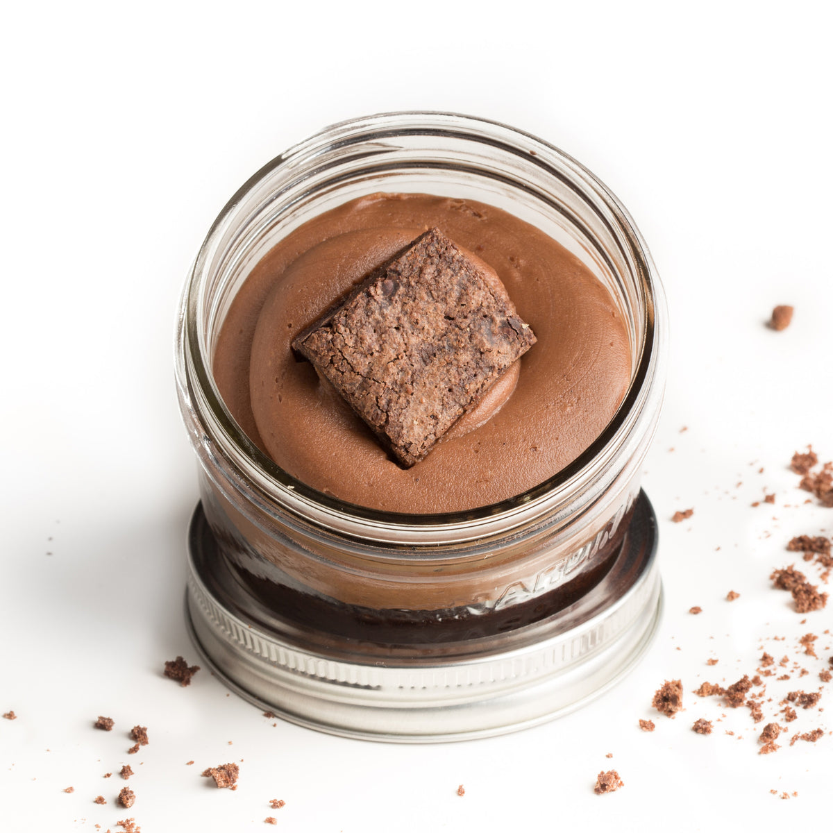 Chocolate Jarcake (available in Mini/Regular sizes) in a jar with personalized sticker option, chocolate frosting, and fudgy brownie piece for nut-free delivery in Toronto.