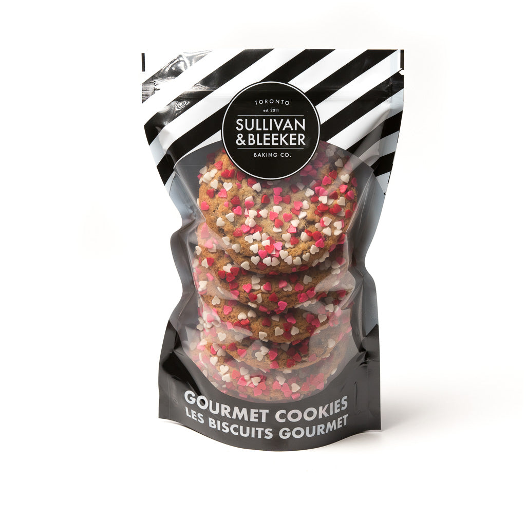 Six-pack of soft-baked Valentine's Day nut-free chocolate chip cookies in a resealable zip-top bag, topped with heart sprinkles for romantic gifts in Toronto.